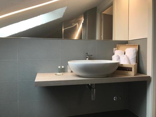 a bathroom with a white sink and a mirror at Locanda Rabaya' in Barbaresco