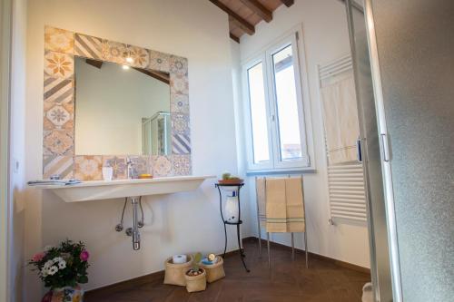 une salle de bain avec un lavabo et un miroir dans l'établissement Casa Laura Capannori, à Capannori