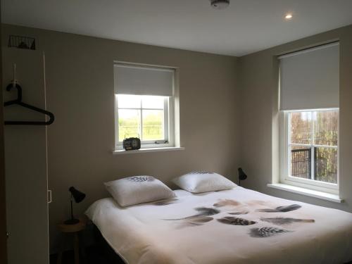 En eller flere senge i et værelse på Mooi, vrij gelegen vakantiehuis dichtbij zee en strand!