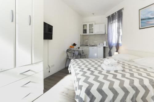 a bedroom with a black and white bed and a kitchen at Villa Supuk in Vinišće