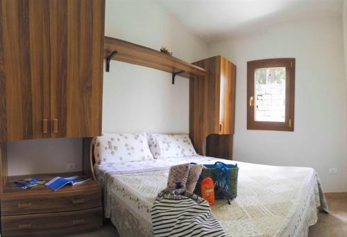 een slaapkamer met een bed en een houten kast bij Agriturismo Antichi Ulivi in Mattinata