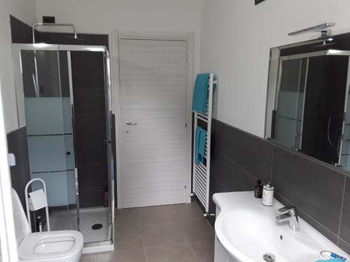 a bathroom with a sink and a toilet and a mirror at Casa Punta Veleno in Brenzone sul Garda