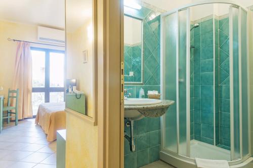 W łazience znajduje się prysznic, umywalka i prysznic. w obiekcie Appartamento Gli Ontani w mieście Cala Liberotto