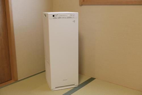 a white refrigerator in the corner of a room at Onyado Yuinosho, Shirakawago in Shirakawa