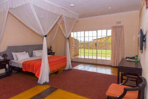 a bedroom with a bed with a canopy at Game Haven Lodge in Blantyre