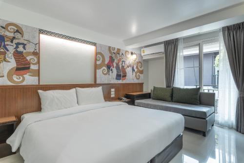 Säng eller sängar i ett rum på Cozytel Chiangmai