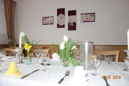 a table with a white table cloth and flowers on it at Hotel Wiedenhof in Hilden