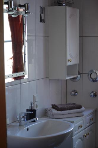 Baño blanco con lavabo y espejo en Weingut Sauer-Kettermann, en Enkirch