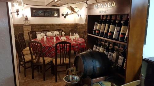 a dining room with a table and a bunch of wine bottles at Хотел Хилез Hotel Hilez in Tryavna