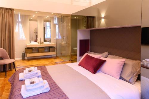a bedroom with a large bed with towels on it at Savoia Suites Torino in Turin