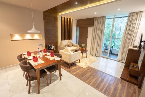 a living room with a dining table and a couch at Blanket Hotel & Spa in Munnar