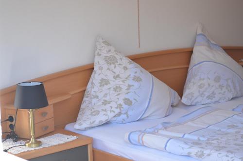 a bed with two pillows and a lamp on a table at Weingut Sauer-Kettermann in Enkirch