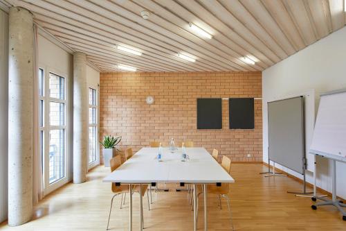 a meeting room with a white table and chairs at Seminarhotel Romerohaus in Luzern