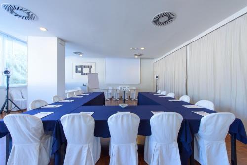a conference room with a blue table and white chairs at Hotel Cristallo in Riccione