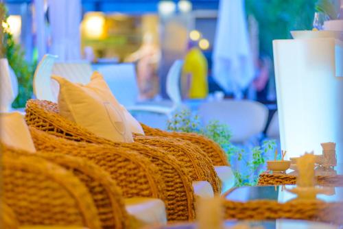 a wicker chair with pillows sitting on a table at Hotel Cristallo in Riccione