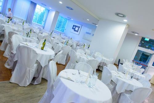 a room full of tables and chairs with white table linen at Hotel Cristallo in Riccione