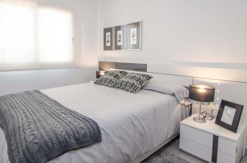 1 dormitorio blanco con 1 cama grande y 2 lámparas en Mar de Pulpí Costa de Almeria by Mar Holidays, en San Juan de los Terreros