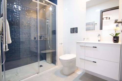 a bathroom with a toilet and a glass shower at Mar de Pulpí Costa de Almeria by Mar Holidays in San Juan de los Terreros