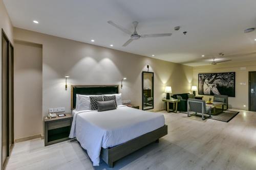 a bedroom with a bed and a living room at Sun-n-Sand Suites, Shirdi in Shirdi