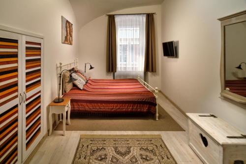 Schlafzimmer mit einem Bett und einem Fenster in der Unterkunft Melody Apartman in Eger