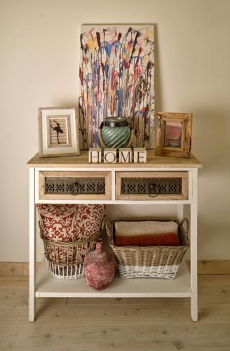 a white console table with two baskets and a painting at Melody Apartman in Eger
