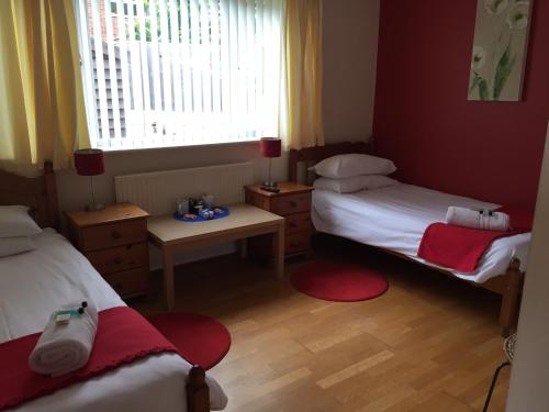 a small room with two beds and a window at Red Lion Accommodation in Abingdon