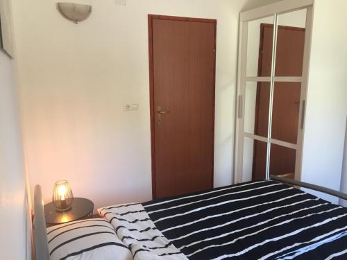 a bedroom with a bed with a blue and white striped blanket at Apartment Emma in Vrbanj