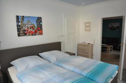 ein Schlafzimmer mit einem Bett und einem Wandgemälde in der Unterkunft Apartmenthaus am Zimmerplatz in Hofheim am Taunus