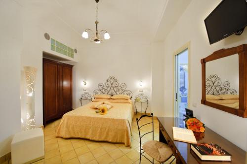 een slaapkamer met een bed en een spiegel bij La Sorgente del Sole in Positano