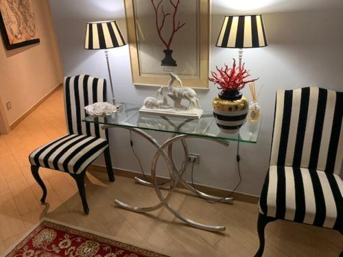 a glass table and two chairs in a room at Residenza Ca' degli Enzi in Verona