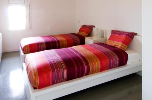 2 camas con mantas coloridas en un estante en Casa Cal Fuster, en Sant Climéns