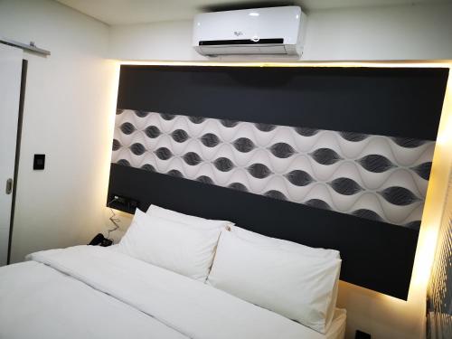 a bedroom with a bed with a laptop on top of it at Jardim das Acácias in Maputo