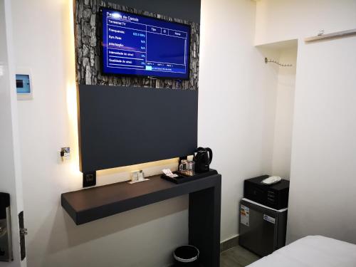 a television on a wall in a hotel room at Jardim das Acácias in Maputo