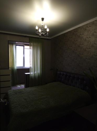 una camera da letto oscura con un letto e una finestra di Апартаменты на Агрба 11/1 a Pizunda