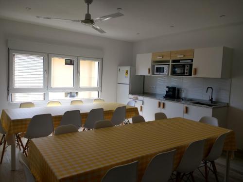 コミージャスにあるAlbergue La Magia del Caminoのテーブルと椅子、キッチンが備わる客室です。