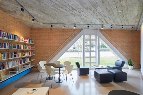 Habitación en el ático con pared de ladrillo, mesa y sillas en Seminarhotel Romerohaus, en Lucerna