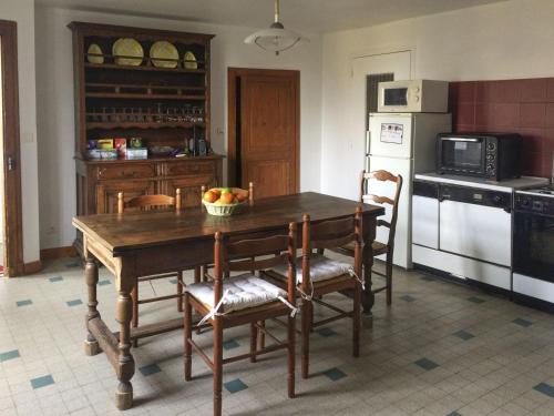 - une cuisine avec une table en bois et un bol de fruits dans l'établissement Retro arty house, à Mesnay