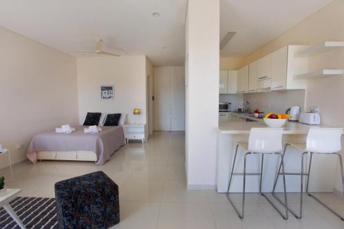 Cet appartement comprend une chambre avec un lit et une cuisine avec une table. dans l'établissement Opera Exclusive Apts by TrulyCyprus, à Limassol