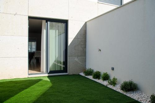 a garden with green grass next to a building at Antónia's house in Ponte de Lima
