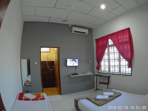 a hospital room with a bed and a tv and a window at Semarak Beach Inn in Dungun