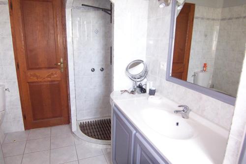 uma casa de banho com um lavatório e um chuveiro com um espelho. em CELESTE em Capo