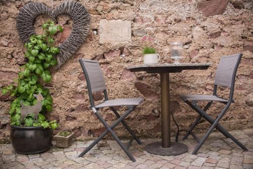 a table and chairs in front of a wall with a heart at Schlafplätzle in Karlstadt