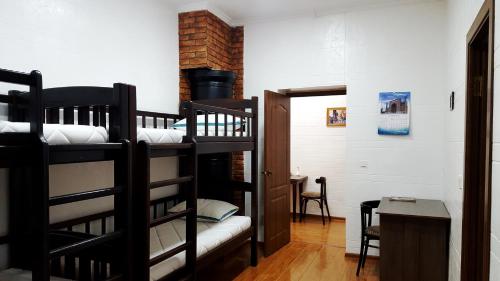 une chambre avec deux lits superposés et une table dans l'établissement Hostel Bravo, à Ferghana