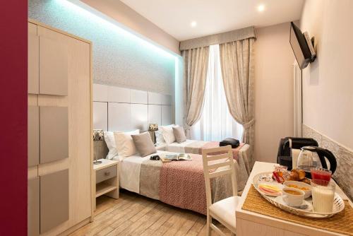 una habitación de hotel con una cama y una mesa con comida. en Five Rooms Rome Guesthouse, en Roma