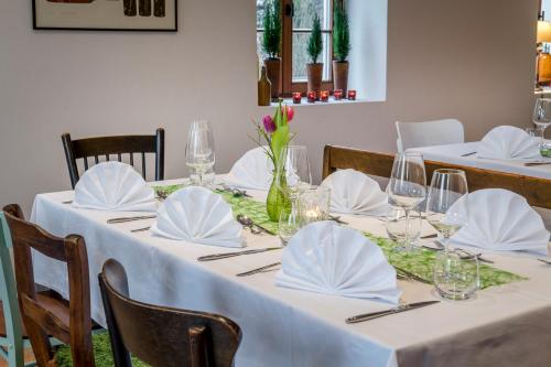 a set of tables with white tablecloths and napkins at Gasthaus Unterwirt in Fridolfing