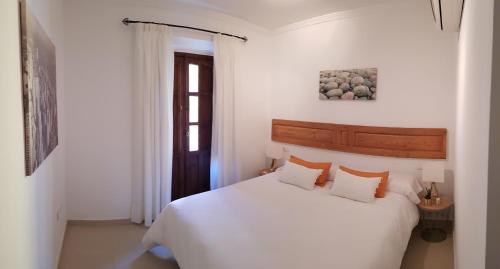 Habitación blanca con cama y ventana en El Marqués San Juan, en Málaga