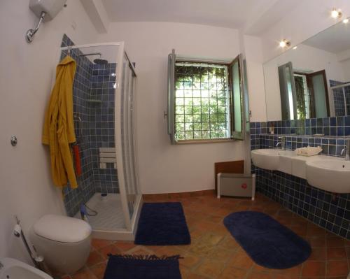 een badkamer met 2 wastafels, een toilet en 2 spiegels bij La Casetta di Borgo Carbone in Locri