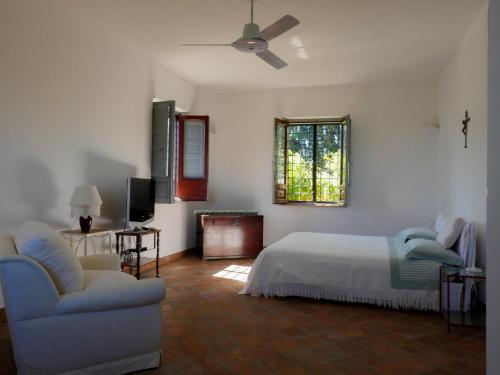 een slaapkamer met een bed, een bank en een raam bij La Casetta di Borgo Carbone in Locri