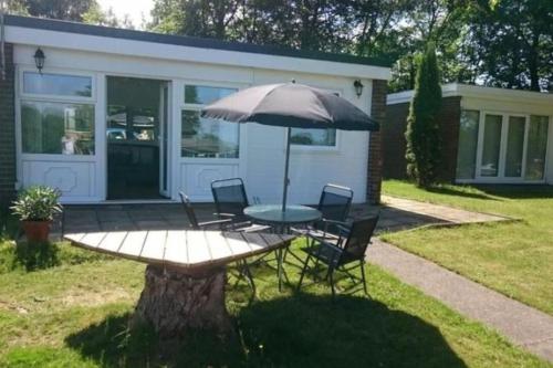 a table and chairs with an umbrella in front of a house at White Lodge in Caernarfon