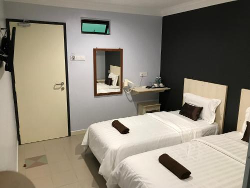 a hotel room with two beds and a mirror at Hotel Seri Kangsar KK Hotel in Kuala Kangsar